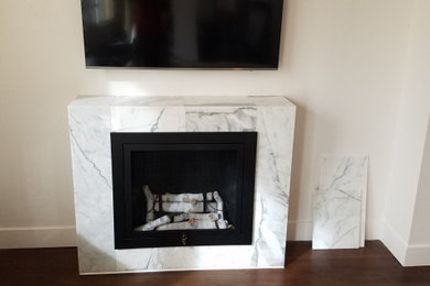 This is an example of a small contemporary living room in Denver with a stone fireplace surround.