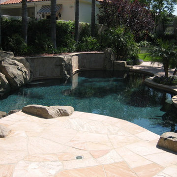 Pool and patio with stone / rock walls and deck