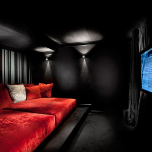 Inspiration for a contemporary home cinema in Other with black walls, carpet, a wall mounted tv and black floors.