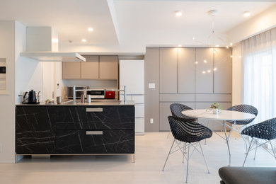 Inspiration for a mid-sized modern galley open plan kitchen in Tokyo with an integrated sink, flat-panel cabinets, black cabinets, stainless steel benchtops, white splashback, black appliances, plywood floors, with island, beige floor and wallpaper.