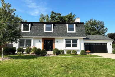 Modelo de fachada de casa blanca y negra de estilo de casa de campo de tamaño medio de dos plantas con revestimiento de ladrillo y panel y listón