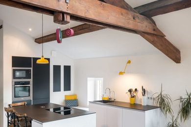 Mid-sized contemporary galley kitchen in Lyon with a single-bowl sink, flat-panel cabinets, white splashback, panelled appliances, grey floor, wood and exposed beam.