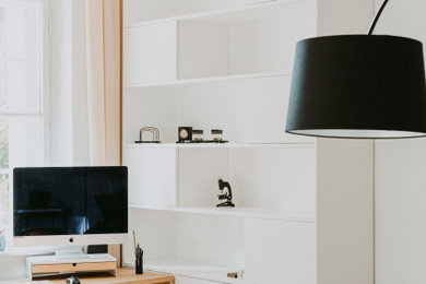 Imagen de despacho actual con paredes blancas y escritorio independiente