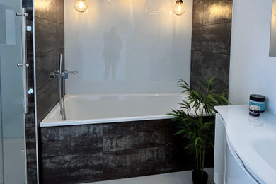 This is an example of a large bohemian grey and white ensuite bathroom in Berkshire with flat-panel cabinets, white cabinets, a built-in bath, an alcove shower, a wall mounted toilet, multi-coloured tiles, porcelain tiles, white walls, porcelain flooring, an integrated sink, glass worktops, grey floors, a hinged door, white worktops, a single sink, a floating vanity unit and a coffered ceiling.