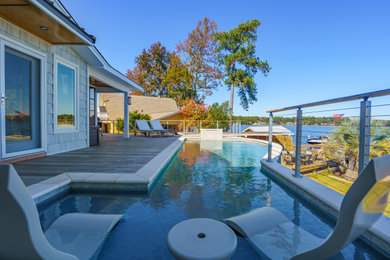 Mid-sized beach style backyard custom-shaped aboveground pool photo in Other with decking