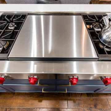 Blue Kitchen Island with white counter top paired with a Wolf Cook Top