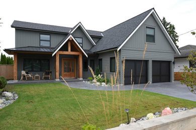 Large contemporary gray two-story concrete fiberboard and board and batten house exterior idea in Vancouver with a mixed material roof and a black roof