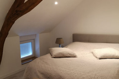 Idée de décoration pour une petite chambre parentale tradition avec un mur blanc, sol en stratifié, un sol beige et poutres apparentes.