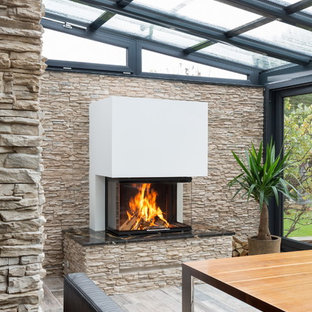 Moderner Wintergarten mit verputzter Kaminumrandung Ideen, Design