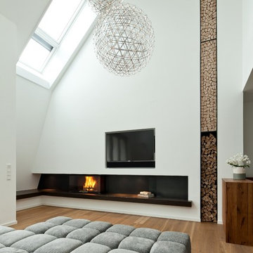 Holzkamin & in die Wand integrierte Holzlege für moderne Dachgeschosswohnung