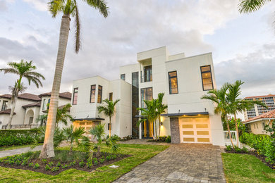 Large modern white three-story stucco exterior home idea in Miami