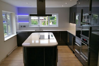 This is an example of a contemporary kitchen/diner in Essex with quartz worktops and an island.