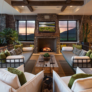 Bild på ett mycket stort funkis allrum med öppen planlösning, med travertin golv, en standard öppen spis, en spiselkrans i sten och en väggmonterad TV