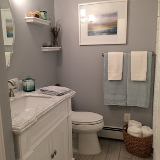 Immagine di una stanza da bagno padronale stile marino di medie dimensioni con consolle stile comò, ante bianche, vasca ad alcova, vasca/doccia, WC monopezzo, piastrelle grigie, piastrelle diamantate, pareti grigie, pavimento in gres porcellanato, lavabo sottopiano, top in marmo, pavimento grigio e doccia con tenda