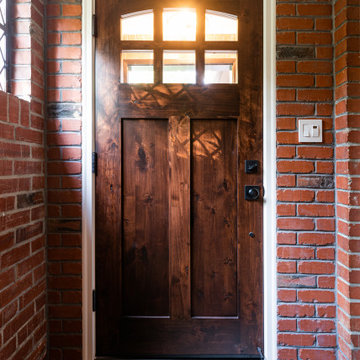 Dark Wood Door with Divided Glass Windows in Red Brick Entryway