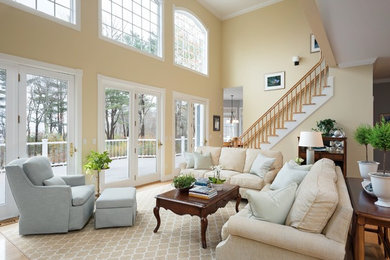 Photo of a mid-sized transitional open concept living room in Portland Maine with beige walls and light hardwood floors.