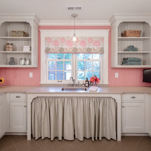 ミネアポリスの大きいトラディショナルスタイルのおしゃれな家事室 (アンダーカウンターシンク、インセット扉のキャビネット、白いキャビネット、人工大理石カウンター、ピンクの壁、セラミックタイルの床、左右配置の洗濯機・乾燥機) の写真