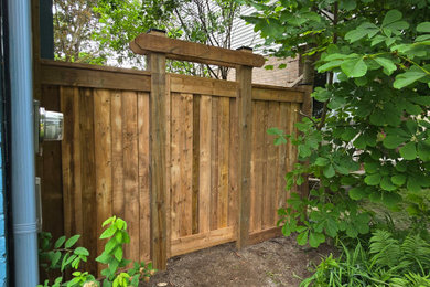 Inspiration for a mid-sized rustic privacy side yard gravel and wood fence landscaping in Other.