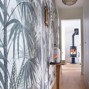 Idéer för en liten eklektisk foajé, med gula väggar, ljust trägolv, en enkeldörr och en gul dörr