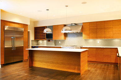 Inspiration for a contemporary dark wood floor kitchen remodel in Vancouver with an undermount sink, flat-panel cabinets, light wood cabinets, quartz countertops, green backsplash, glass tile backsplash, stainless steel appliances and an island