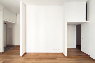 Esempio di un soggiorno design di medie dimensioni e aperto con pareti bianche, pavimento in legno verniciato e nessun camino