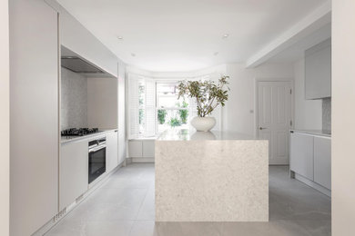 Design ideas for a large contemporary grey and white u-shaped enclosed kitchen in London with an integrated sink, flat-panel cabinets, grey cabinets, engineered stone countertops, grey splashback, stone slab splashback, integrated appliances, porcelain flooring, an island, grey floors and grey worktops.