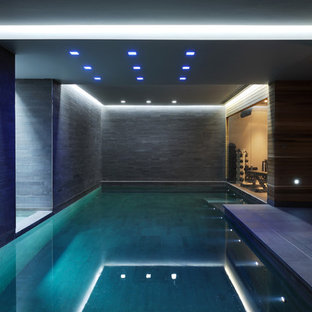 Imagen de sótano en el subsuelo contemporáneo, grande, con paredes grises, suelo de baldosas de porcelana y suelo gris