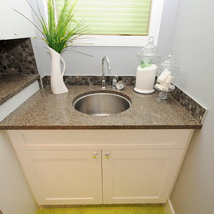 エドモントンの中サイズのトラディショナルスタイルのおしゃれな家事室 (アンダーカウンターシンク、シェーカースタイル扉のキャビネット、白いキャビネット、テラゾーカウンター、グレーの壁、左右配置の洗濯機・乾燥機、磁器タイルの床、ベージュの床) の写真