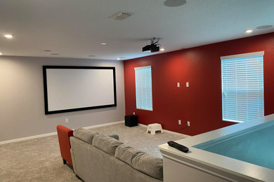 Ejemplo de cine en casa abierto de tamaño medio con televisor colgado en la pared