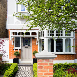 Immagine di una porta d'ingresso classica di medie dimensioni con pareti rosse, pavimento con piastrelle in ceramica, una porta singola e una porta marrone