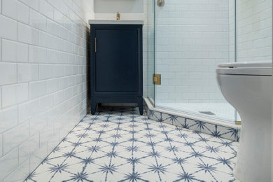Small transitional kids' white tile and ceramic tile porcelain tile, blue floor, single-sink and wainscoting corner shower photo in DC Metro with furniture-like cabinets, blue cabinets, a two-piece toilet, blue walls, an integrated sink, solid surface countertops, a hinged shower door, white countertops, a niche and a freestanding vanity