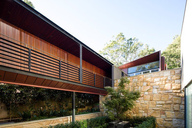 Photo of an expansive modern two-storey exterior in Sydney with wood siding.