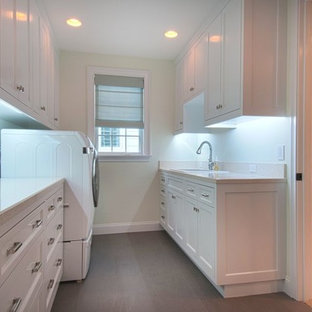 Photo of a medium sized classic galley laundry cupboard in Orange County with a built-in sink, shaker cabinets, white cabinets, recycled glass countertops, white walls, a side by side washer and dryer, ceramic flooring and brown floors.