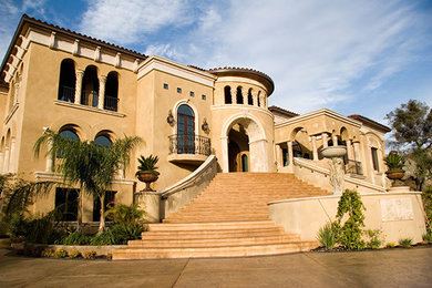 This is an example of an expansive mediterranean three-storey stucco beige house exterior in Sacramento with a clipped gable roof and a tile roof.