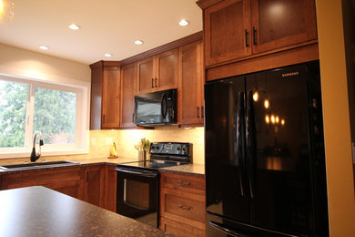 Eat-in kitchen - traditional l-shaped linoleum floor eat-in kitchen idea in Vancouver with an undermount sink, shaker cabinets, medium tone wood cabinets, laminate countertops, travertine backsplash, black appliances and an island