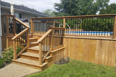 Example of a mid-sized transitional backyard deck design in Toronto with no cover
