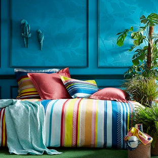 Aménagement d'une chambre exotique de taille moyenne avec un mur bleu, aucune cheminée et un sol vert.