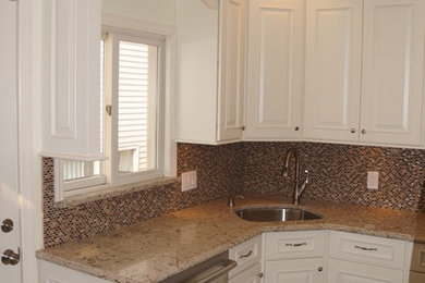 Example of a small classic u-shaped porcelain tile enclosed kitchen design in New York with an undermount sink, raised-panel cabinets, white cabinets, quartzite countertops, green backsplash, porcelain backsplash, stainless steel appliances and no island