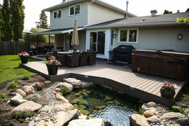 Photo of a mid-sized traditional backyard deck in Edmonton with a roof extension.