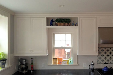 Mid-sized elegant l-shaped light wood floor eat-in kitchen photo in Minneapolis with an undermount sink, white cabinets, soapstone countertops, multicolored backsplash, porcelain backsplash, stainless steel appliances and an island