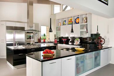 Inspiration for a large contemporary u-shaped concrete floor open concept kitchen remodel in San Francisco with an undermount sink, flat-panel cabinets, black cabinets, granite countertops, black backsplash, stone slab backsplash, stainless steel appliances and an island