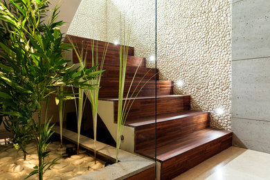 Design ideas for a mid-sized modern wood l-shaped staircase in Montreal with wood risers and glass railing.