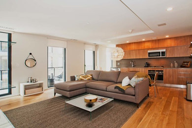 Example of a mid-sized minimalist formal medium tone wood floor and brown floor living room design in New York with white walls and no fireplace