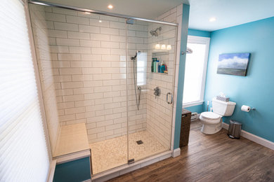 Inspiration for a mid-sized timeless master white tile and ceramic tile porcelain tile, brown floor and single-sink bathroom remodel in Philadelphia with flat-panel cabinets, white cabinets, a two-piece toilet, blue walls, an undermount sink, quartz countertops, white countertops and a built-in vanity