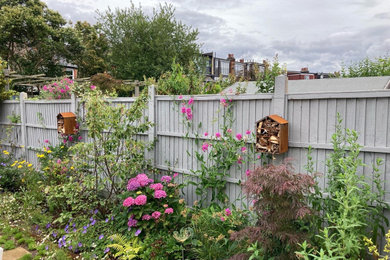 ロンドンにあるお手頃価格の中くらいな、夏のインダストリアルスタイルのおしゃれな庭 (ゼリスケープ、半日向、コンクリート敷き	、ウッドフェンス) の写真