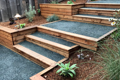 This is an example of a rustic drought-tolerant hillside decomposed granite and wood fence retaining wall landscape in San Francisco for spring.
