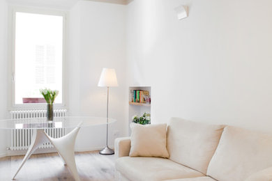 Design ideas for a scandinavian living room in Bologna with white walls and light hardwood floors.