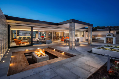 Example of a huge trendy patio design in Orange County with a fire pit and no cover