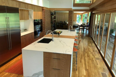 リッチモンドにあるモダンスタイルのおしゃれなキッチン (人工大理石カウンター、白いキッチンパネル、石スラブのキッチンパネル、シルバーの調理設備、白いキッチンカウンター) の写真
