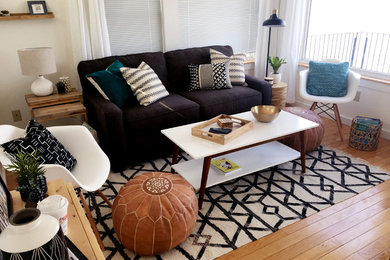 Example of a trendy enclosed medium tone wood floor and brown floor living room design in Burlington with beige walls